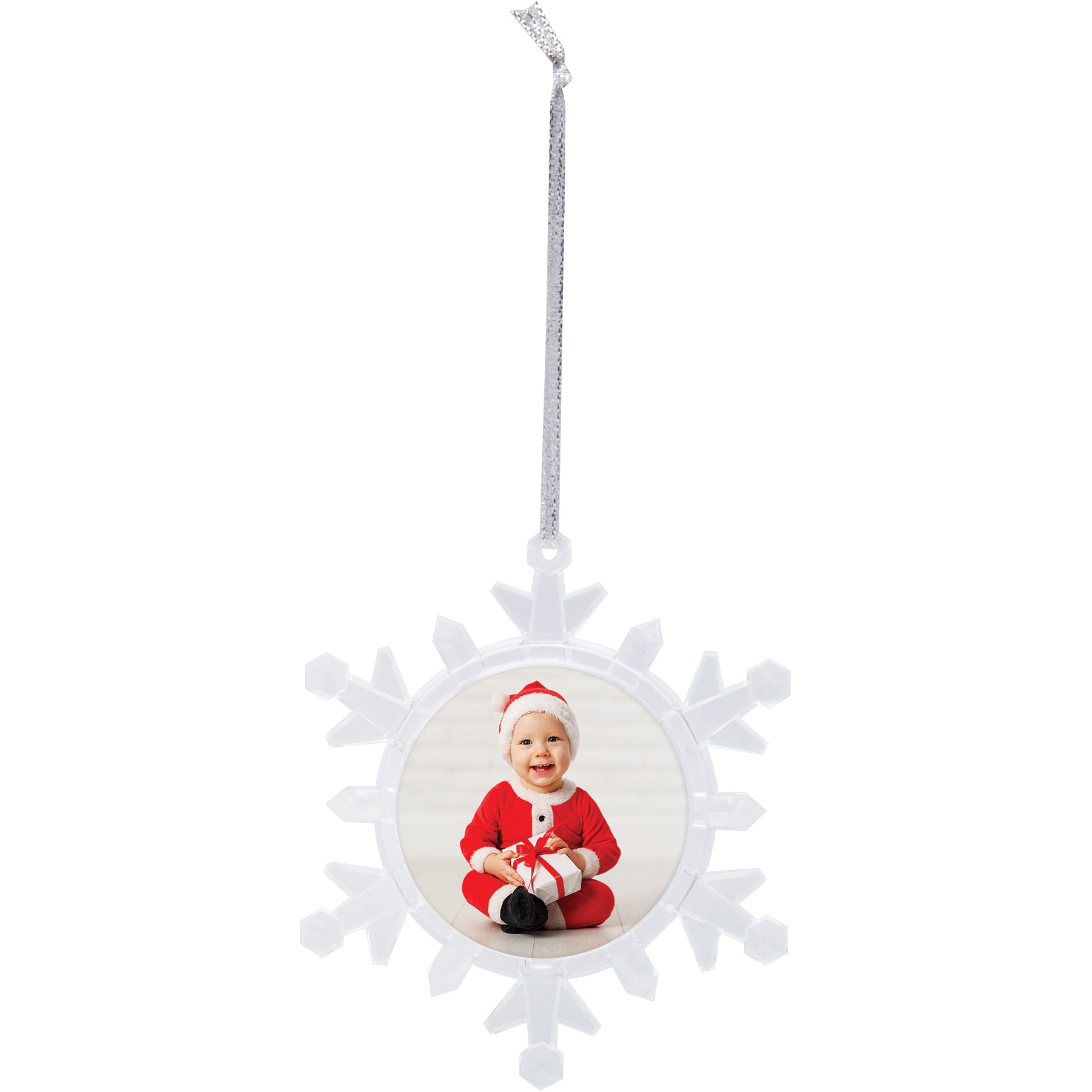 A clear plastic snowflake-shaped photo ornament with a beveled edge, displaying a photo of a smiling child in Santa attire in the center, hanging by silver ribbon on a white background.