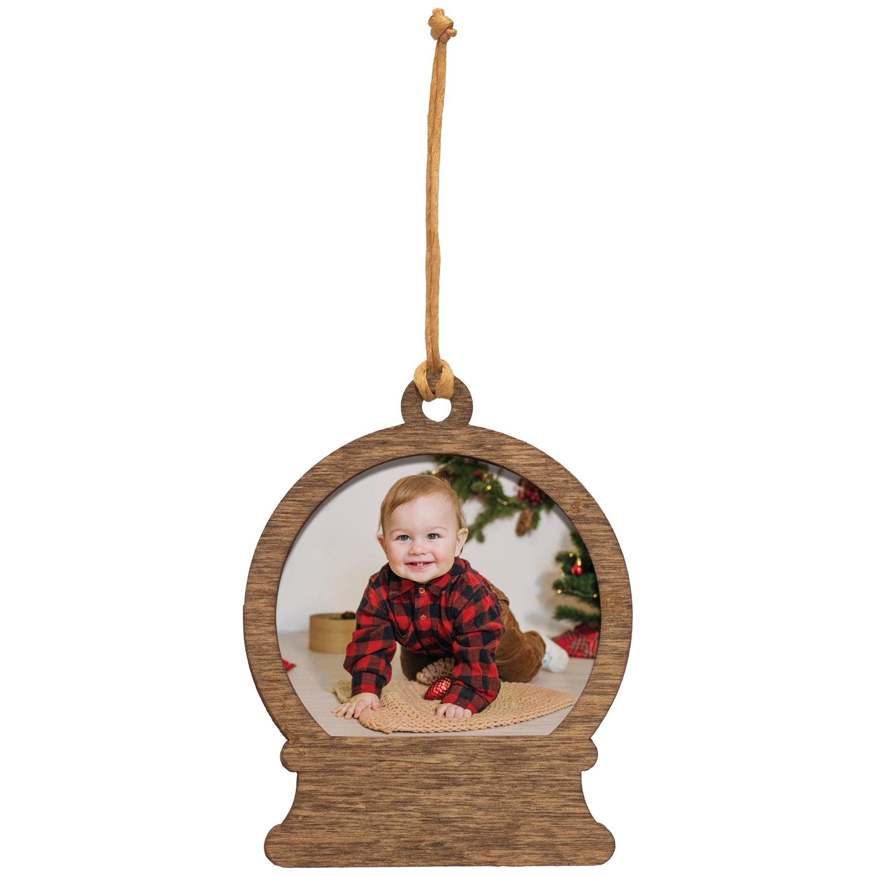 A wooden snow globe-shaped photo ornament with a picture of a baby inside, hanging by a raffia string.
