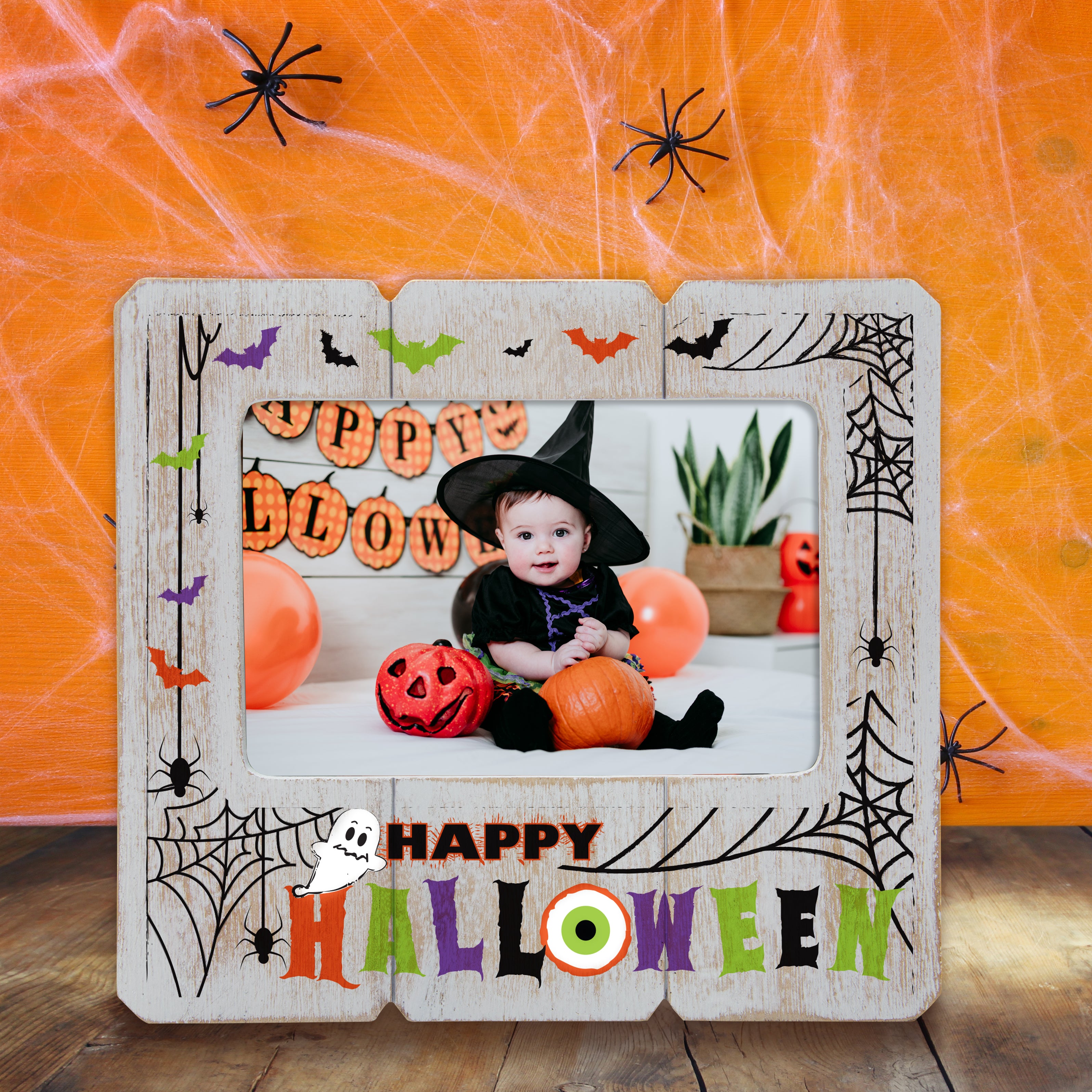 Halloween-themed photo frame with a child in a witch costume and pumpkins on an orange spiderweb background.
