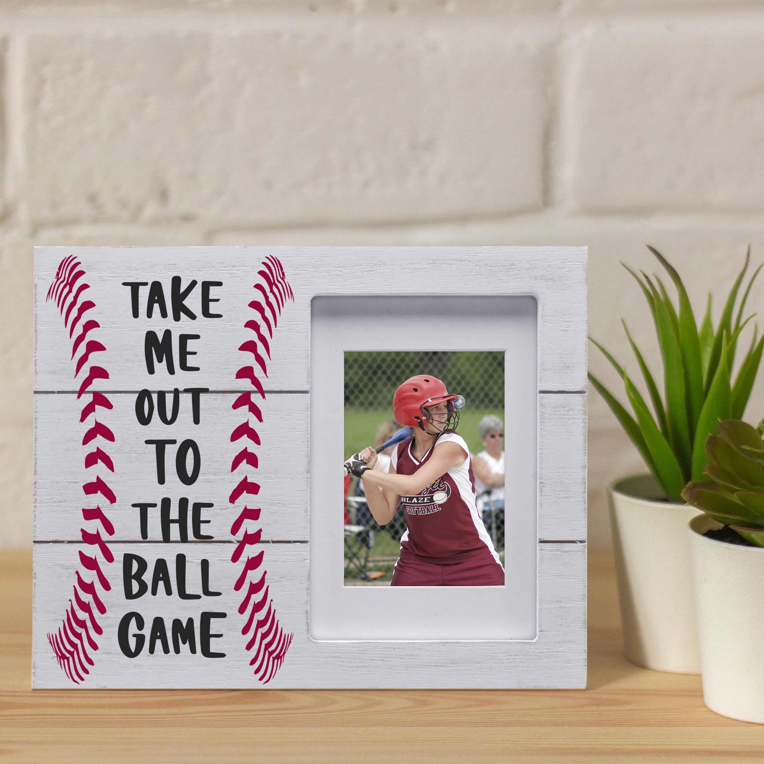 White baseball themed picture frame shown in a home setting on a table with plants.