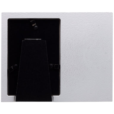 Back side of a white wood picture frame showing the black easel used for tabletop display.