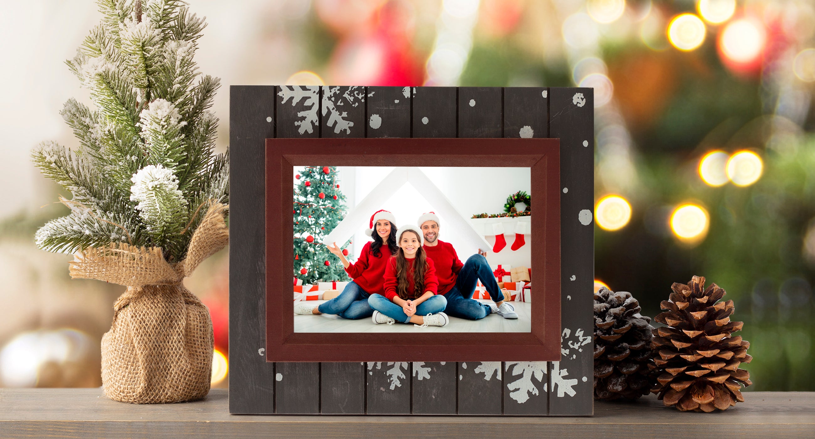 A rectangular brown wood picture frame with a rustic finish. The frame is adorned with white snowflake designs on the brown section. This picture frame is shown in a home setting on a mantel or shelf.