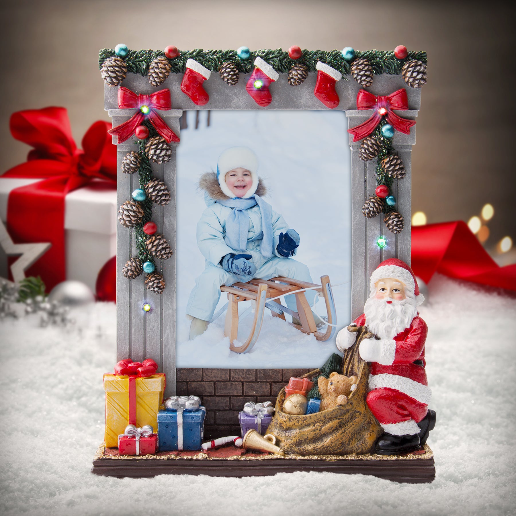 A gray colored light-up resin picture frame with hand painted details featuring garland, stockings, presents, Santa, and more on a festive lifestyle background.