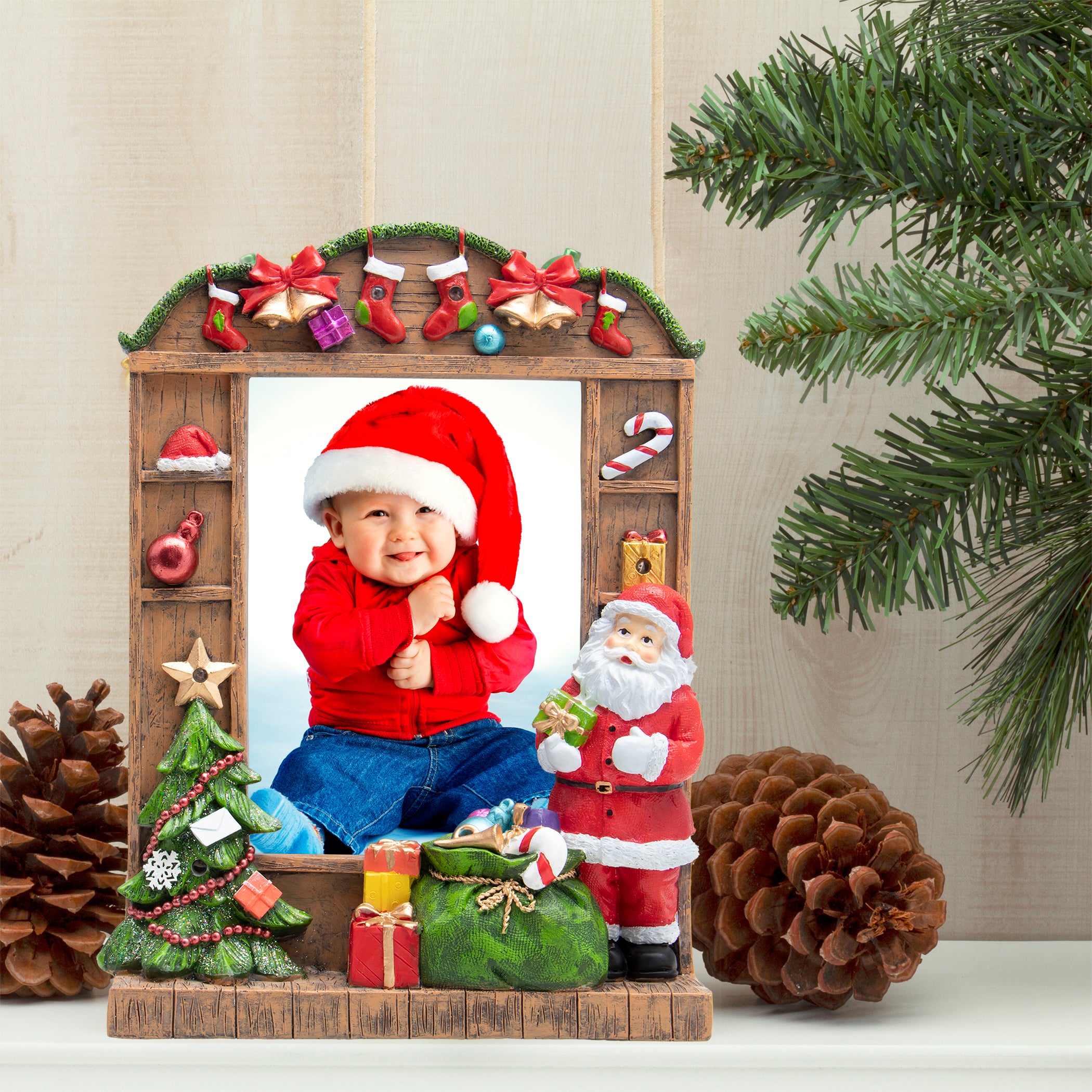 A resin picture frame with a Christmas theme, featuring Santa Claus, a Christmas tree, and wrapped presents. The frame is designed to hold a 5" x 7" photo and has multicolored lights along its border on a festive lifestyle background.