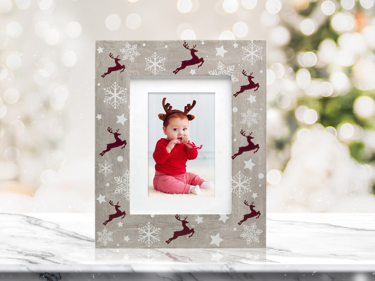 A rustic wooden picture frame with a reindeer and Christmas-themed pattern on a festive lifestyle background.