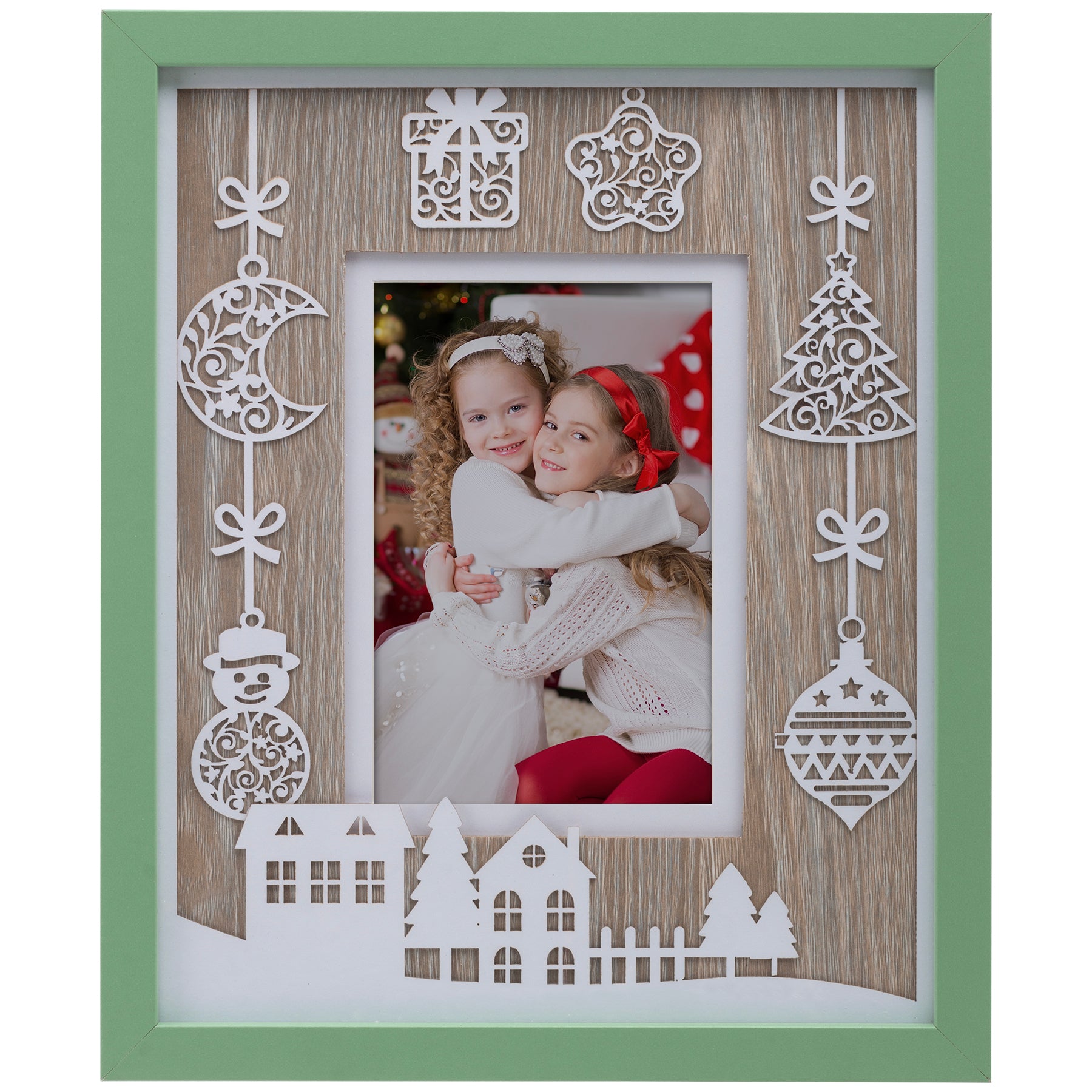A wooden picture frame with a green border, featuring white laser cut designs including ornaments and houses with trees.