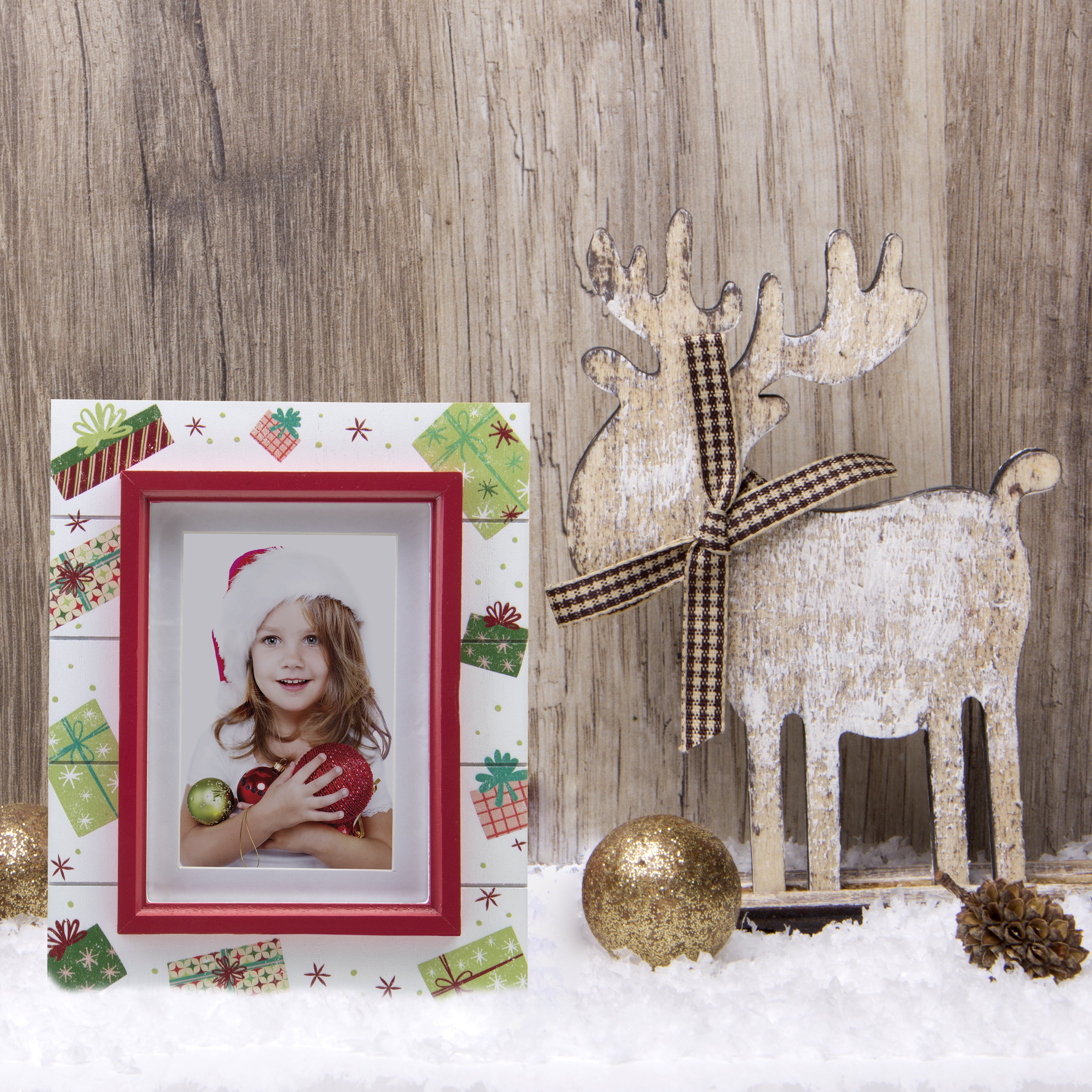 A wooden picture frame with a shiplap design and a rustic worn finish, featuring white as the base color with red trim, decorated with painted Christmas presents and gifts on a festive lifestyle background.