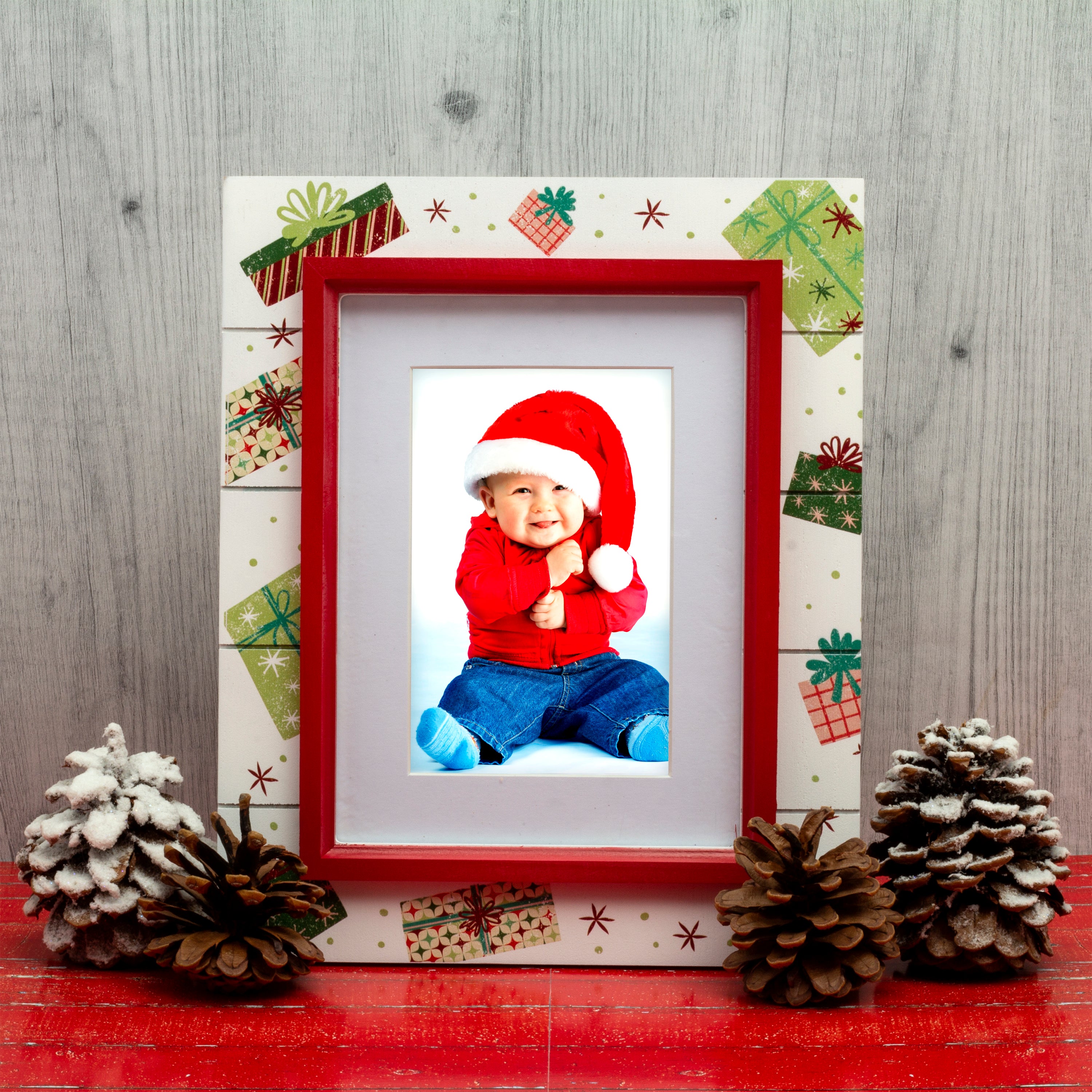 A wooden picture frame with a shiplap design and a rustic worn finish, featuring white as the base color with red trim, decorated with painted Christmas presents and gifts on a festive lifestyle background.