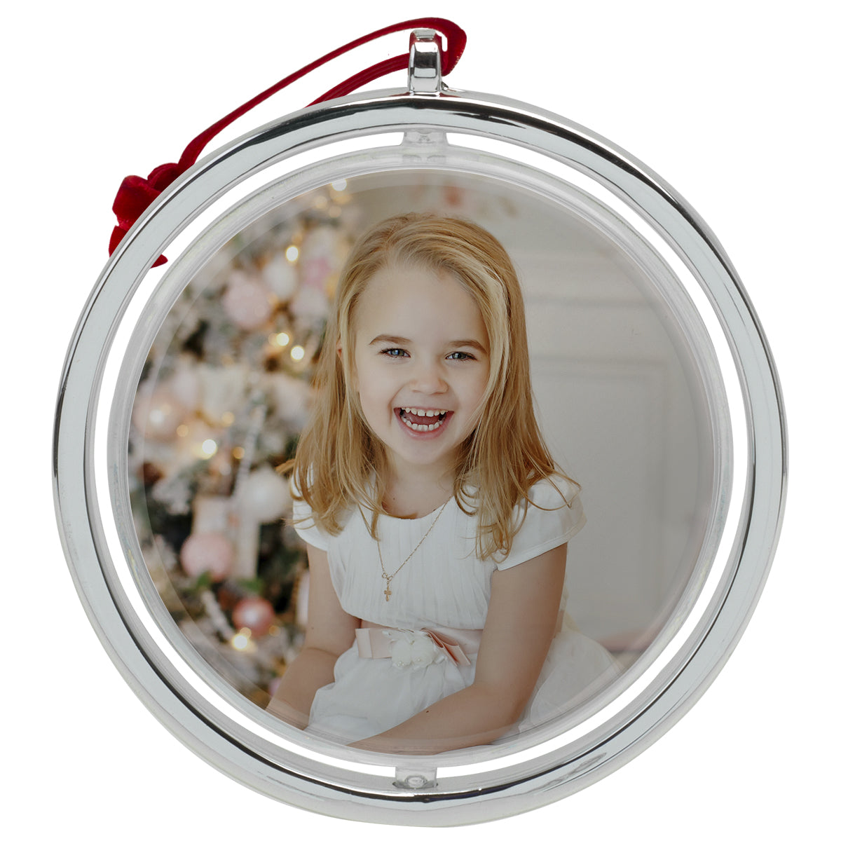 A round, silver photo ornament with a red velvet string at the top on a white background.