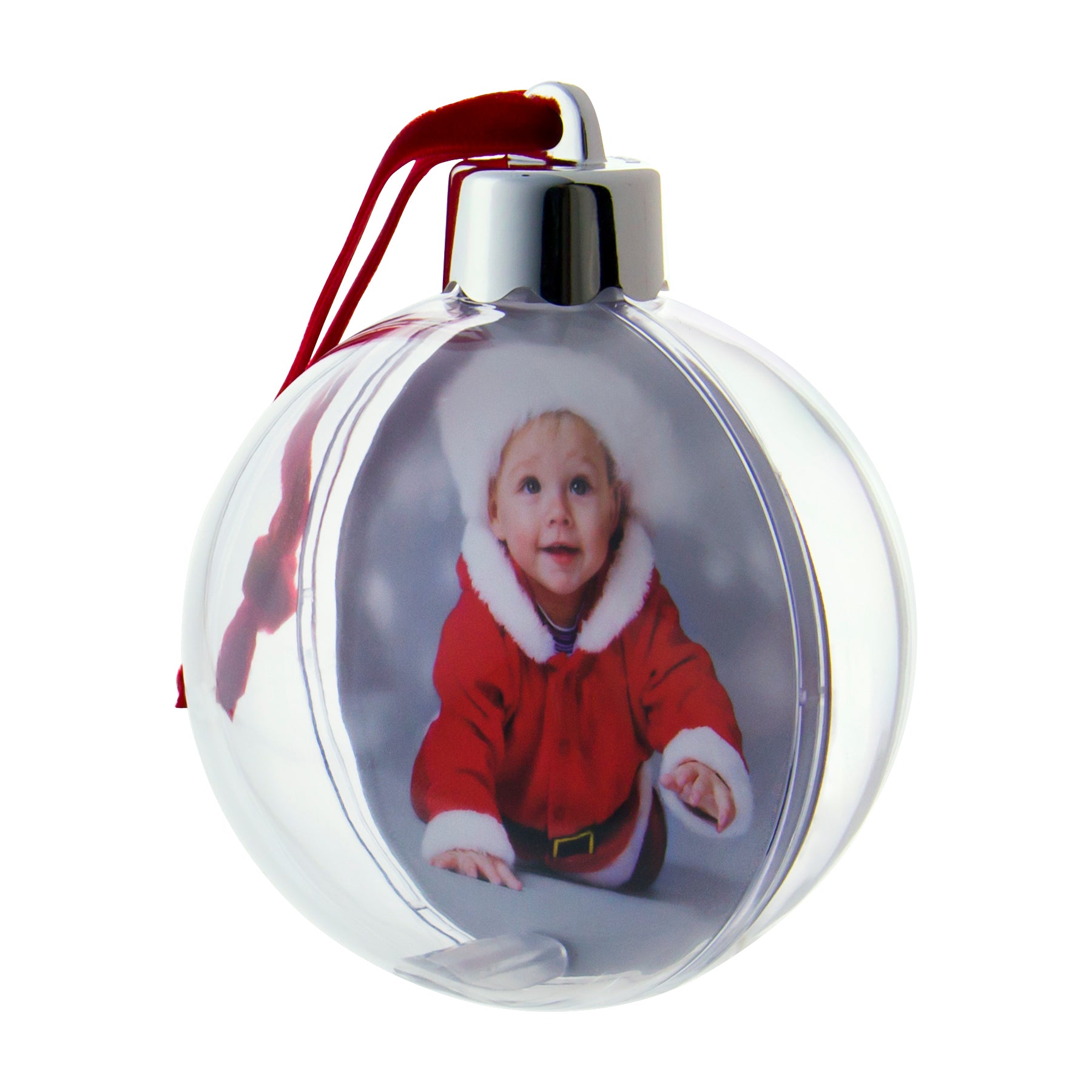 A clear, round Christmas ornament with a photo of a smiling child in Santa attire, and a red velvet hanger ribbon showcasing an angled display of the photo ornament on a white background.