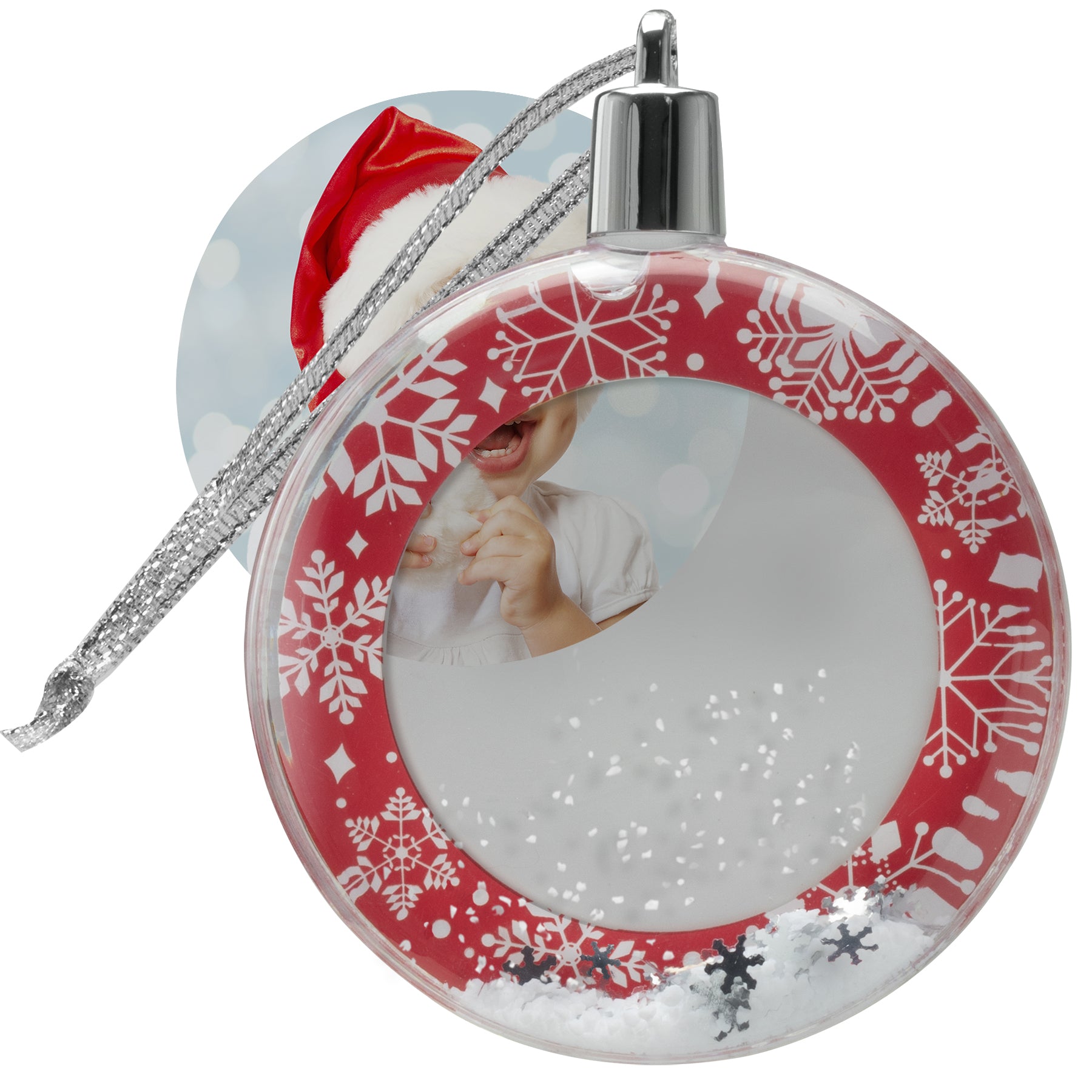 A round snow globe photo ornament with a red border and white snowflakes showcasing how to insert a photo into the ornament.