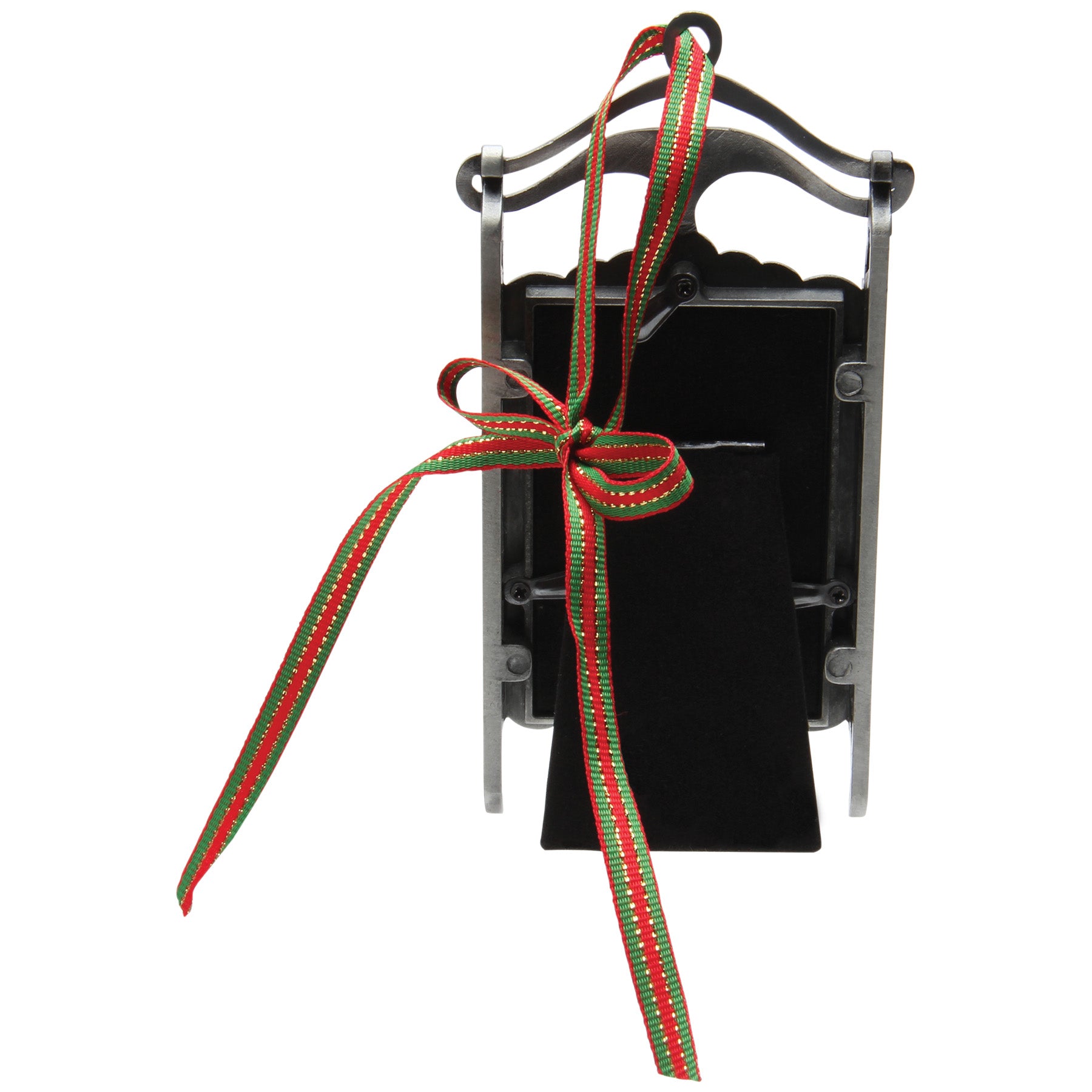 The back side of a pewter sled-shaped photo ornament and picture frame adorned with a red, green, and gold ribbon showcasing the back velvet easel for tabletop display on a white background.