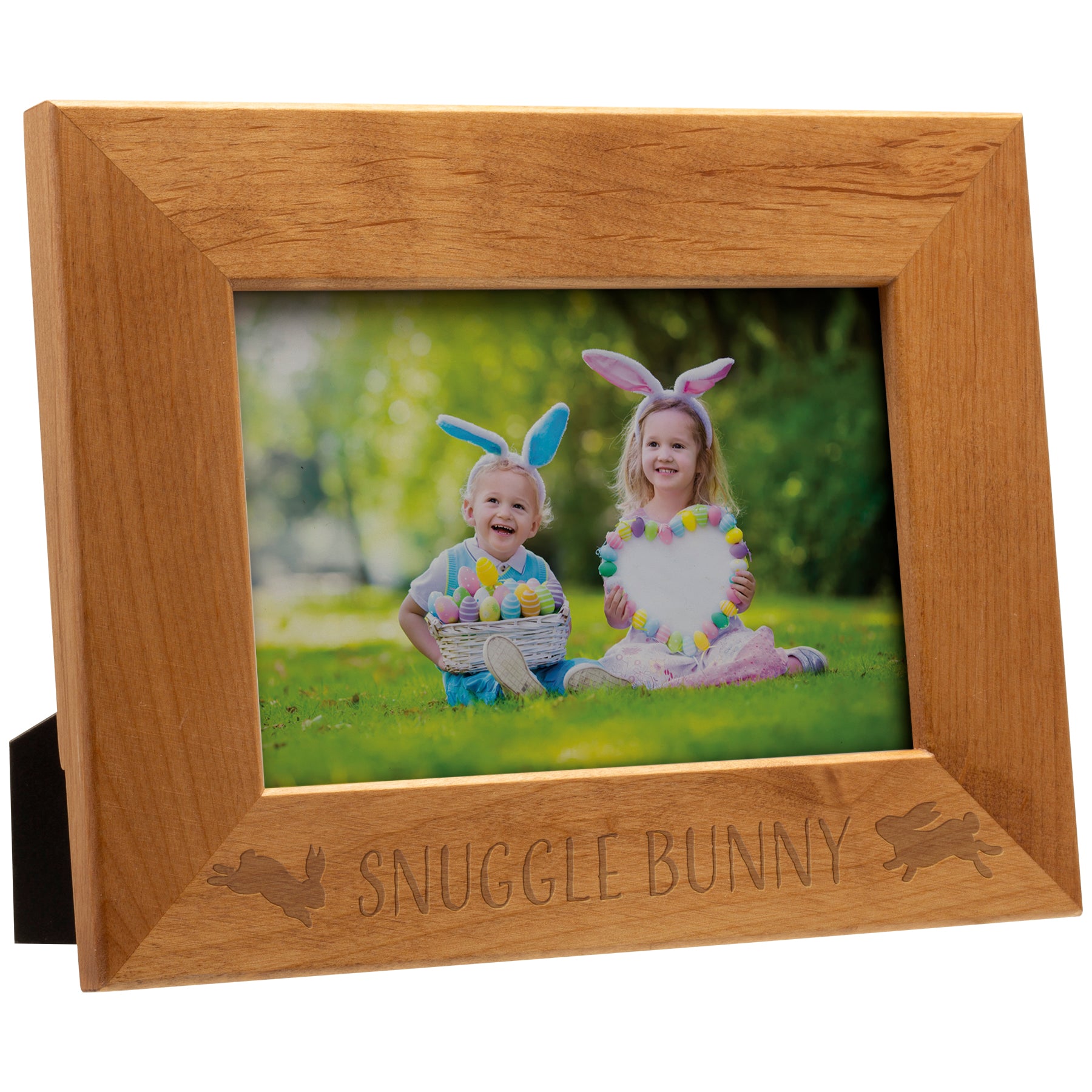 Wooden photo frame with 'Snuggle Bunny' engraving, containing a photo of two children wearing bunny ears outdoors.