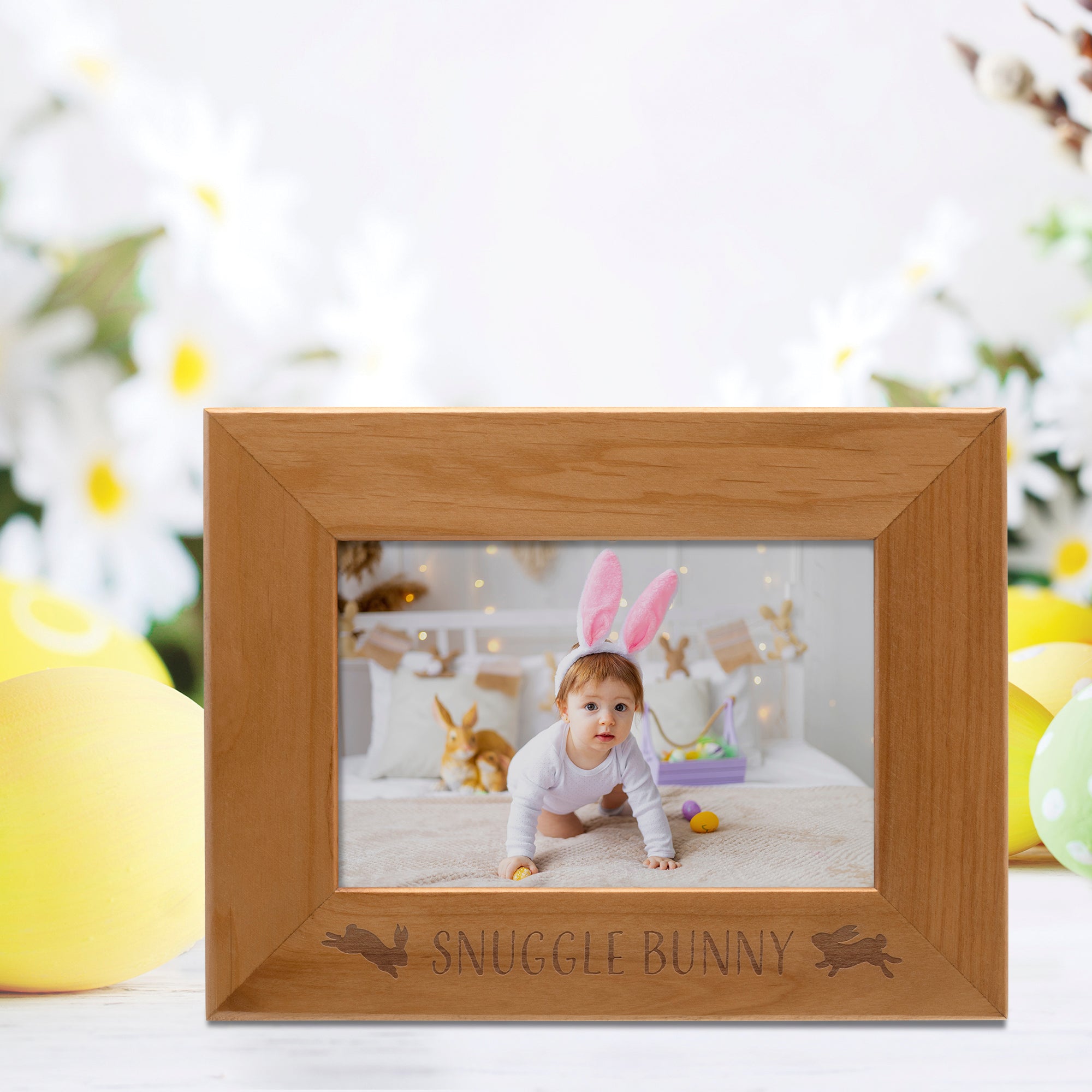 Wooden photo frame with 'Snuggle Bunny' engraving, displaying a child in bunny ears against a blurred festive background.