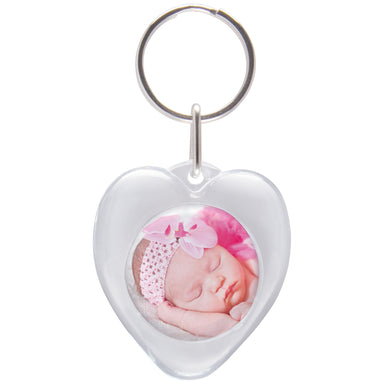 A heart-shaped clear plastic keychain with a snap-in photo of a baby.